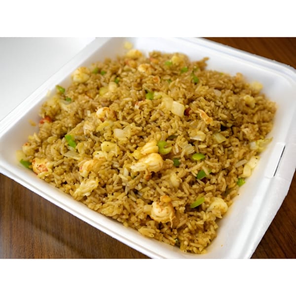 Close-up of DaDam Crab's seafood fried rice with shrimp, green onions, and other vegetables in a white takeout container.